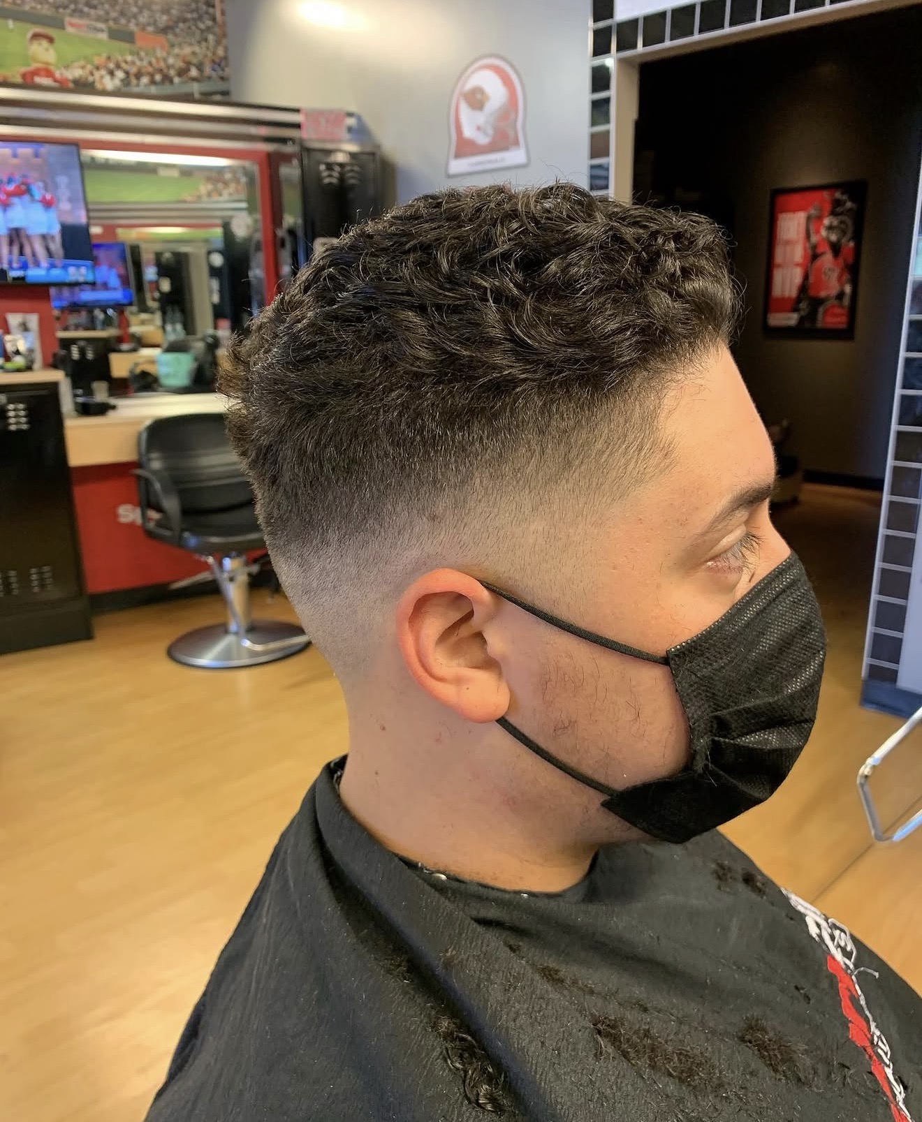 Curly top with clean low fade by Kay