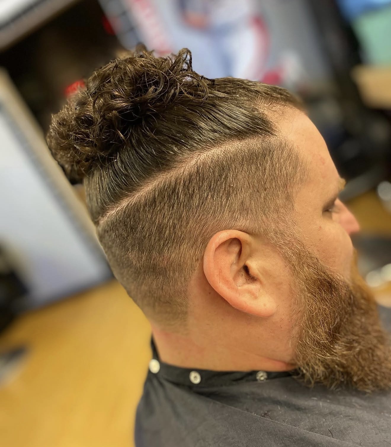 Man bun with clean taper fade by Kay